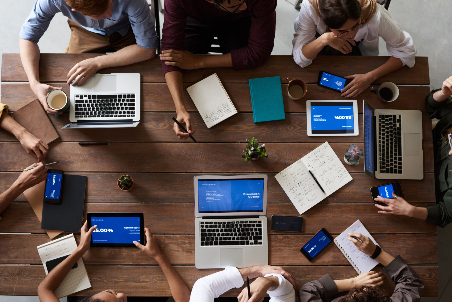Vista superior de un equipo trabajando con laptops, tablets y datos en una mesa de reunión